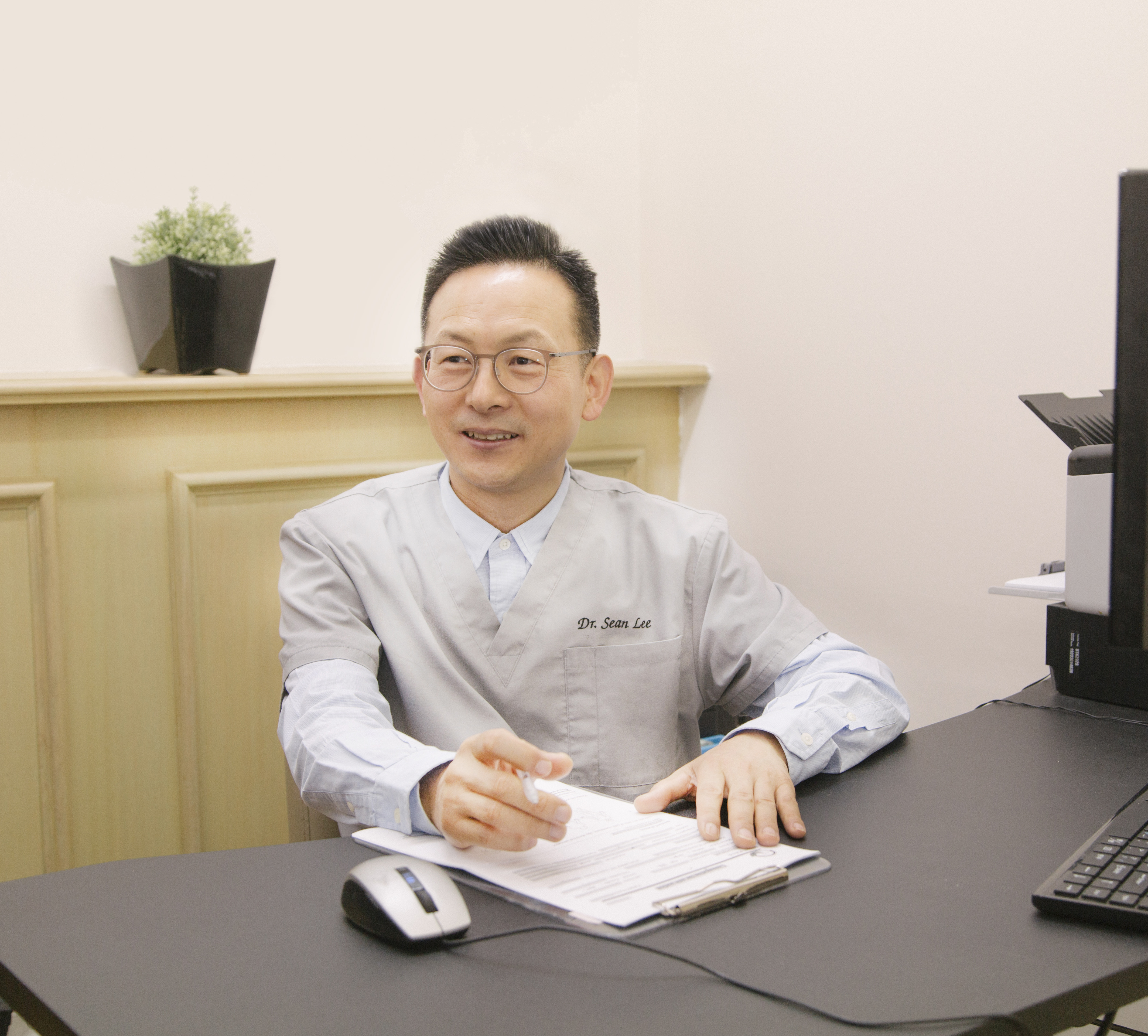 Dr Sean Lee seated in the clinic